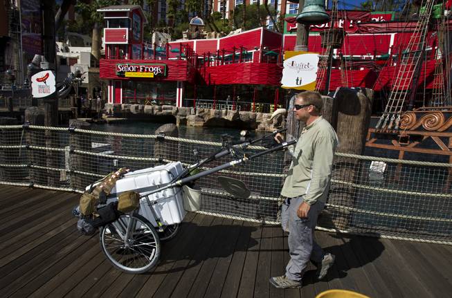 “The Walking Man” Karl Bushby makes his way along Las Vegas Boulevard South past Treasure Island on Monday, Oct. 14, 2013, with his cart “The Beast” on his way to Caesars Palace for a three-day stay.