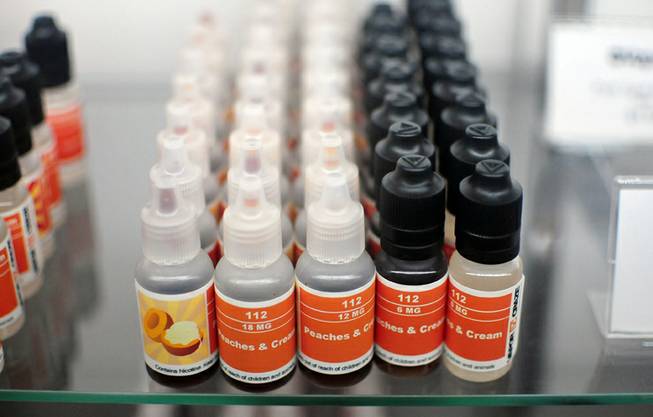 Several vials of flavored, liquid nicotine and non-nicotine "juices" are on display at The Vapery, a local vapor shop located at 8060 S. Rainbow Road, on Friday, Oct. 11, 2013. The rise in e-cigarette use among young adults and teenagers is a growing concern among health officials, who have long waged a public health campaign against smoking.