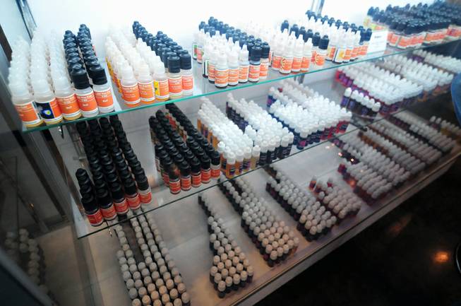 Dozens of vials of flavored, liquid nicotine and non-nicotine "juices" are on display at The Vapery, a vapor shop located at 8060 S. Rainbow Road, on Friday, Oct. 11, 2013. The rise in e-cigarette use among young adults and teenagers is a growing concern among health officials, who have long waged a public health campaign against smoking.