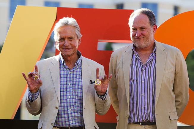 Actor Michael Douglas, left, and director Jon Turteltaub pose during a ceremony for cast members of "Last Vegas" in front of the Bellagio Friday, Oct. 18, 2013. Douglas is holding "gaming chips" from Clark County and the Las Vegas mayor's office. Las Vegas Mayor Carolyn Goodman and Clark County Commission Chairman Steve Sisolak declared Oct. 18, 2013 to be "Last Vegas Day" in Las Vegas and Clark County. The movie by CBS Films opens nationwide on November 1.