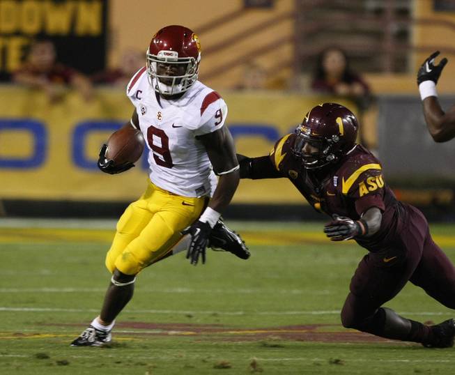 Southern California wide receiver Marqise Lee (9) gets tackled by Arizona State Marion Grice (1) during the second half of an NCAA college football game on Saturday, Sept. 28 2013, in Tempe, Ariz. Lee was hurt on the play and never returned to the game. 