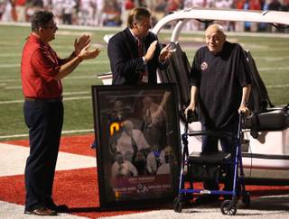 Fresno State University President Joseph Castro and Athletic Director Thomas Boeh applaud Fresno State alumni Jerry Tarkanian during the first half of an NCAA college football game Saturday, Oct. 19, 2013, in Fresno, Calif. (AP Photo/Gary Kazanjian)