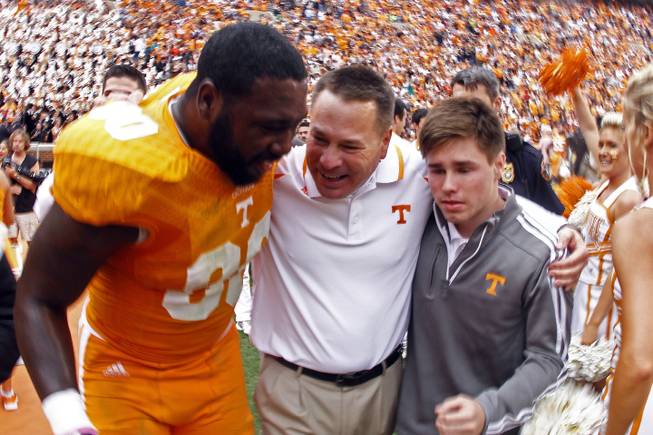 Tennessee head coach Butch Jones, center, celebrates with Tennessee defensive lineman Malik Brown (90) and his son, Alex Jones, after defeating South Carolina 23-21 in an NCAA college football game on Saturday, Oct. 19, 2013 in Knoxville, Tenn. 