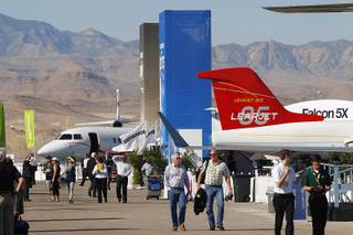 Attendees walk among aircraft during a static display of jets at the Henderson Executive Airport Tuesday, Oct. 22, 2013 as part of the National Business Aviation Association convention.