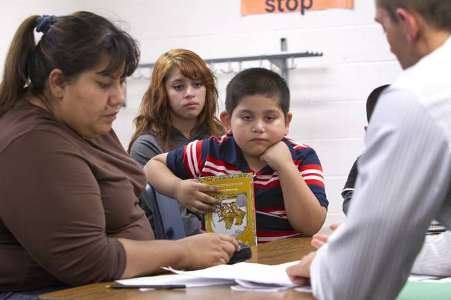 Melynda Espinoza (background),15, interprets for her mother Irene during a parent-teacher conference for her brother Miguel, center, at Lois Craig Elementary School in North Las Vegas Wednesday, Oct. 23, 2013. About 80 percent of students at the school are Hispanic.