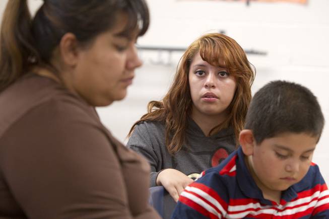 Melynda Espinoza, center,15, interprets for her mother Irene during a parent-teacher conference for her brother Miguel, center, at Lois Craig Elementary School in North Las Vegas Wednesday, Oct. 23, 2013. About 80 percent of students at the school are Hispanic.