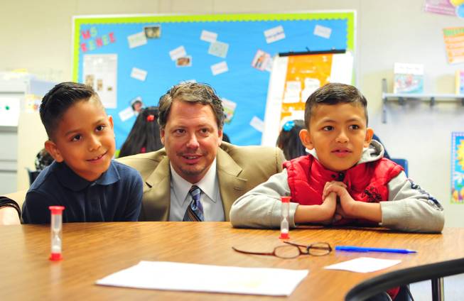 A reading tutor works with third-grade English-language learner students Jezreel Figueroa-Prado, 9, (left) and Enrique Reyes-Avila, 8, (right) as Clark County Schools Superintendent Pat Skorkowsky looks on at a Zoom Reading Center on Wednesday, October 23, 2013, at Lunt Elementary School.