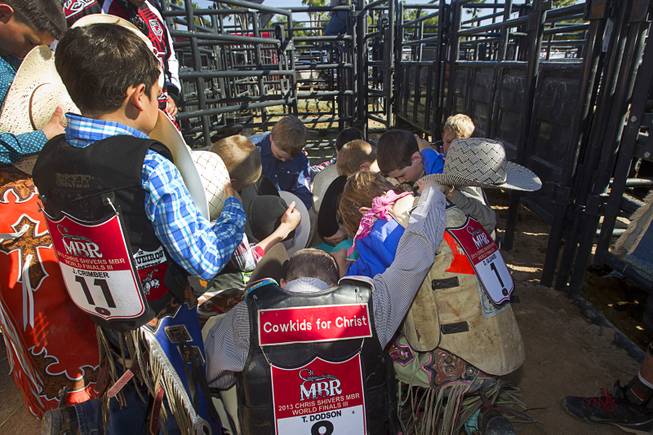 "Cowkids For Christ" junior riders gather for a prayer before competing in the Chris Shivers Miniature Bull Riding (MBR) World Finals at Mandalay Bay Thursday, Oct. 24, 2013. The MBR features junior riders ages 8 to11 and senior riders ages 12 to 14. The event was part of the the 2013 Professional Bull Riders Built Ford Tough World Finals.