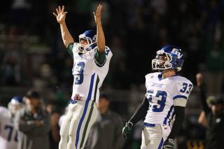 Green Valley holder Kyler Chavez signals good as kicker Conor Perkins' field goal splits the uprights during their game against Canyon Springs Thursday, Oct. 24, 2013. Green Valley won 44-43 on the last second field goal.