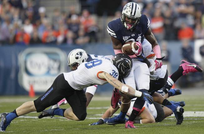 BYU's Jamaal Williams takes a hit from Boise State's Corey Bell during an NCAA college football game, Friday, Oct. 25, 2013 at LaVell Edwards Stadium in Provo, Utah. 