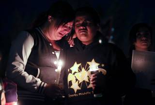 Jeannette Vasquez, 14, and Carlos Lara, 13, were among hundreds of students and residents who attended a candlelight vigil at Sparks Middle School in Sparks, Nev., on Wednesday, Oct. 23, 2013, in honor of slain teacher Michael Landsberry and two 12-year-old students who were injured after a fellow student open fire at the school on Monday, before turning the gun on himself.  