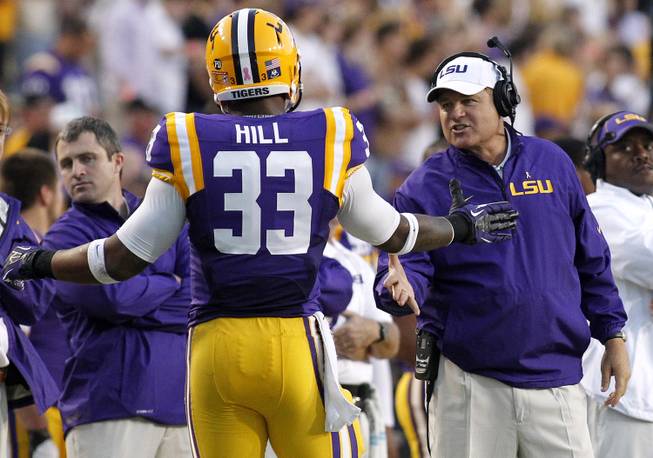 LSU head coach Les Miles congratulates running back Jeremy Hill (33) during the fist half of the NCAA college football game against Furman in Baton Rouge, La., Saturday, Oct, 26, 2013. LSU won 48-16. 