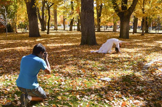 Using the falling autumn leaves on the state capitol grounds as a backdrop, Jerit Shuman photographs his mother, Lilliam, on Sunday, Oct. 27, 2013. The Shumans are from Gardnerville.