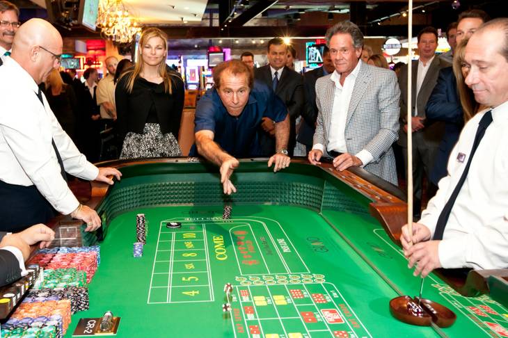 Steve Wynn rolls the dice after placing a $2,000 bet during the opening of the Downtown Grand Las Vegas Hotel and Casino on Sunday, Oct. 27, 2013.