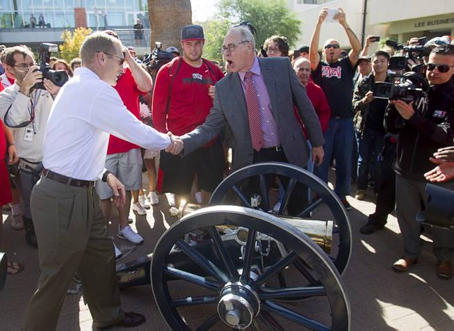 Head Football coach Bobby Hauck, left, is congratulated by UNLV President Neal Smatresk by the Fremont cannon before a painting ceremony on UNLV campus Monday, Oct. 28, 2013. The UNLV football team beat Reno Saturday 27-22 to break an eight-year losing streak in the rivalry game and gain possession of the Fremont cannon. 