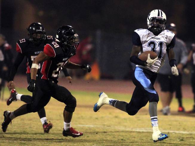 (From right) Canyon Springs Kyhren Howard runs by Las Vegas' Justin Taitague after picking up a punt that Las Vegas blocked. Canyon Springs defeated Las Vegas High 21-14 on Friday, Nov. 1, 2013.