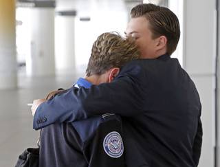 Transportation Security Administration employees hug outside Terminal 1 at Los Angeles International Airport on Friday, Nov. 1, 2013. A gunman armed with a semi-automatic rifle opened fire at Los Angeles International Airport on Friday, killing a Transportation Security Administration employee and wounding three other people. Flights were disrupted nationwide.