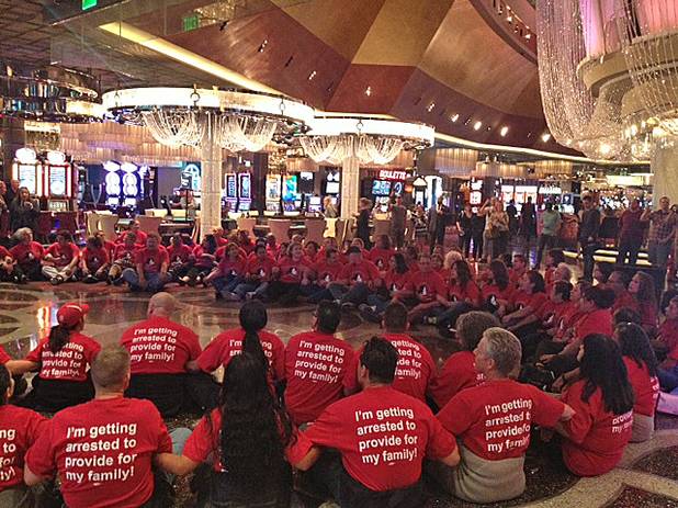 Dozens of Culinary Union members sit beneath the chandeliers just inside the Cosmopolitan as part of a protest, Friday, Nov. 1, 2013.