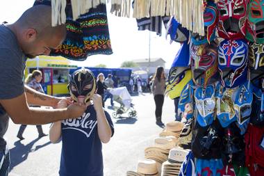 Anthony Alvarez, 9,  tries on a Mexican luchador (wrestling) mask with his father Miguel at the Broadacres Marketplace & Events Center Sunday Nov. 3, 2013.