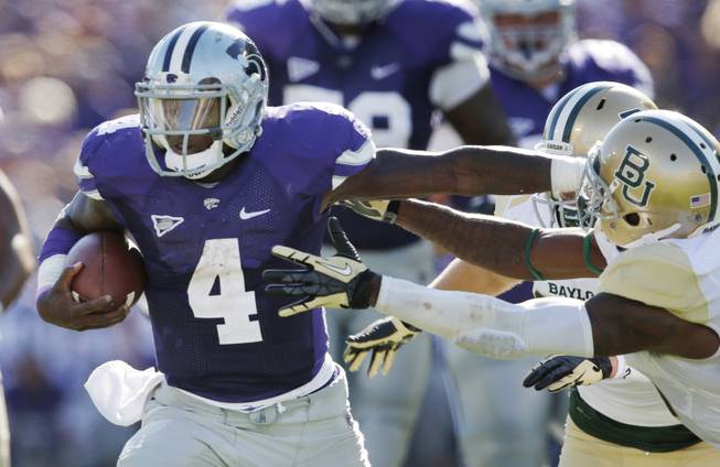 Kansas State quarterback Daniel Sams (4) stiff-arms his way past Baylor safety Ahmad Dixon, right, during the first half of an NCAA college football game in Manhattan, Kan., Saturday, Oct. 12, 2013. 