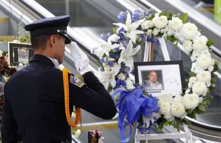 TSA officer Fritz Corros salutes at Los Angeles International Airport, during a moment of silence Friday Nov. 8, 2013, to honor the Transportation Security Administration officer Gerardo Hernandez, killed by a gunman at the airport a week ago.