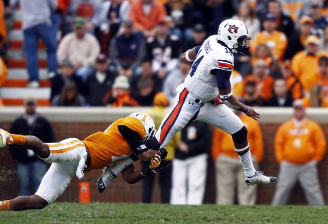 Auburn quarterback Nick Marshall (14) tries to get away from Tennessee linebacker Brent Brewer (17) in the third quarter of an NCAA college football game on Saturday, Nov. 9, 2013 in Knoxville, Tenn. 