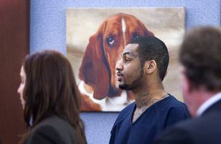 A painting of a basset hound is shown behind defendant Ammar Harris, the suspect the Feb. 21 Las Vegas Strip shooting and car crash that killed three people, as he appears in Judge Kathleen Delaney's courtroom at the Regional Justice Center Wednesday, Oct. 30, 2013. The courtroom is decorated with multiple paintings of basset hounds. 