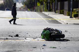 A pedestrian passes by a fatal motorcycle accident at the intersection of Flamingo and Lindell roads Thursday, Nov. 14, 2013.