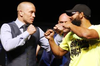 Welterweight champion Georges St. Pierre and challenger Johny Hendrics face off during a news conference Thursday, Nov. 14, 2013 in advance of UFC 167.