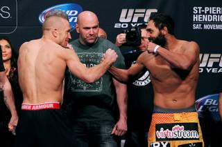 Georges St. Pierre and Johny Hendricks face off during the weigh in for UFC 167 Friday, Nov. 15, 2013.