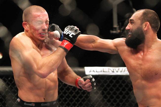 Johny Hendricks hits Georges St. Pierre with a right during their title fight at UFC 167 on Saturday, Nov. 16, 2013, at the MGM Grand Garden Arena. St. Pierre won with a controversial split decision.