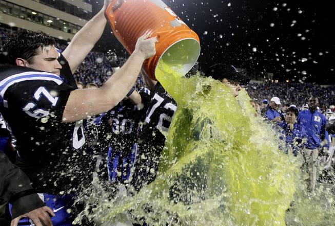 Duke coach David Cutcliffe is doused with Gatorade by Lucas Patrick after the Blue Devils' 48-30 win against Miami in Durham, N.C., on Saturday, Nov. 16, 2013. 
