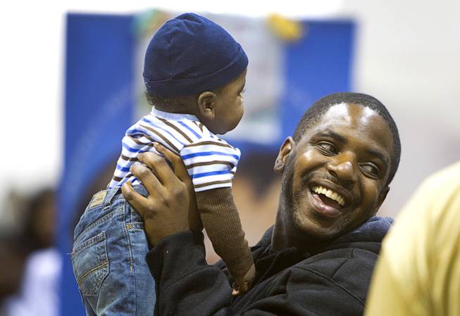 Marquis Ware plays with his son Marquis Ware Jr. as they wait in line for dental care during the Fall 2013 Southern Nevada Project Homeless Connect at Cashman Field Center Tuesday, Nov. 19, 2013. The annual event brings together a variety of social and legal services to help homeless and low-income people.