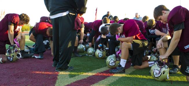Faith Lutheran players and coaches gather for a group prayer at the start of practice on Tuesday as they gear up for their Division I-A state high school football championship game against Churchill County of Fallon.  Nov. 19, 2013.  