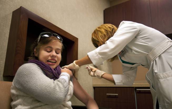Jenny Stiles receives her regular B-12 shot from Von's pharmacist Olga Brostrom to keep her energy up, which is depleted by her triweekly dialysis sessions, Wednesday, Nov. 20, 2013.  Jenny is on the kidney transplant list for the second time.