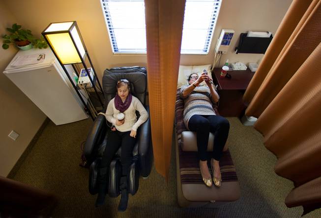 (From left) Jenny Stiles and her mom Karen relax with automatic back massages prior to beginning their chiropractic sessions with Dr. Scott Wallace on Wednesday, Nov. 20, 2013.