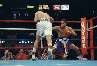 Challenger Hector Camacho gets down low in the corner while trying to avoid the relentless charge of champion Julioi Cesar Chavez during the third round of their WBC super lightweight title fight in Las Vegas, Nev., Sept 12, 1992. 