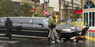 A limo driver walks away from the accident scene as a Las Vegas police officer approaches the mobile chair she struck along E. Ogden Avenue and N. Third Street. The rider was transported by ambulance with unknown injuries Thursday, Nov. 21, 2013.  L.E. Baskow