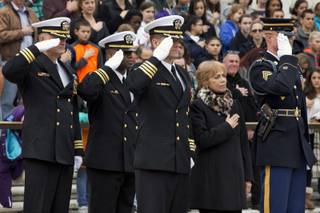 Navy SEALs salute at left, with Carmella LaSpada, a White House aide to President John F. Kennedy, and an Honor Guard soldier from the 3rd U.S. Infantry Regiment, called ''The Old Guard,'' right, at a wreath as  during the placing of a special wreath at the Tomb of the Unknowns in tribute to Kennedy, Friday, Nov. 22, 2013, at Arlington National Cemetery in Arlington, Va.,, on the 50th anniversary of Kennedy's death. 