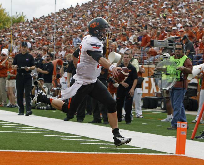 Oklahoma State quarterback Clint Chelf scores a touchdown against Texas during the second quarter of an NCAA college football game Saturday, Nov. 16, 2013, in Austin, Texas. 