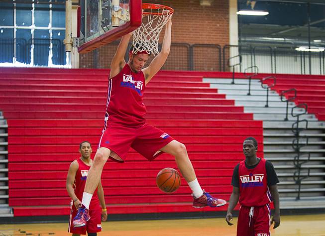 Valley High School's Spencer Mathis hangs on the rim after a dunk during practice at the school Tuesday, Nov. 26, 2013.