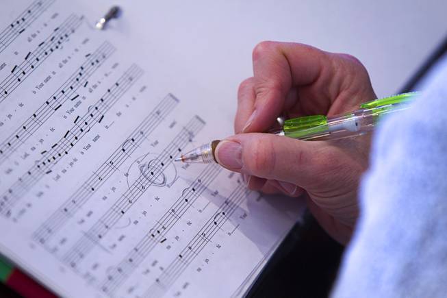 A member of the Myron Heaton Chorale makes a notation in sheet music during rehearsal at Christ the Servant Lutheran Church in Henderson Tuesday, Nov. 26, 2013. The Chorale are scheduled to perform at the church on Dec. 8.