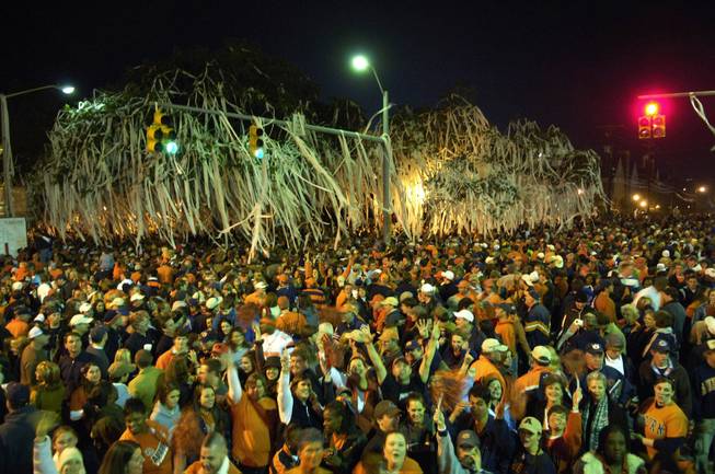 In this Nov. 19, 2005 file phot, Auburn fans celebrate by Toomer's Corners after their 28-18 win over Alabama in the Iron Bowl NCAA college football game in Auburn, Ala. The maddening, thrilling, all-consuming Alabama-Auburn rivalry polarized an entire state long before an overzealous Crimson Tide fan allegedly dealt the latest low blow by poisoning the Toomer's Corner oaks. 
