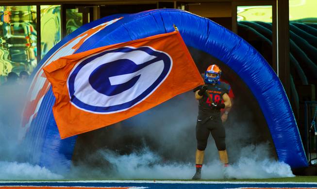 Bishop Gorman's Chris Lalli (48) waves a flag as his team readies to leave the tunnel onto the field for the regional championships on Saturday, Nov. 30, 2013.  L.E. Baskow