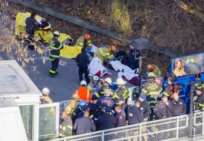 Injured people are tended to by first responders near the site of the derailment of a Metro-North passenger train in the Bronx borough of New York, Sunday, Dec. 1, 2013. The train derailed on a curved section of track in the Bronx on Sunday morning, coming to rest just inches from the water and causing multiple fatalities and dozens of injuries, authorities said. Metropolitan Transportation Authority police say the train derailed near the Spuyten Duyvil station.