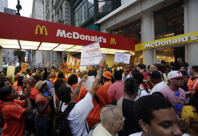 In this Thursday, Aug. 29, 2013, file photo, protesting fast food workers demonstrate outside a McDonald's restaurant on New York's Fifth Avenue, in New York. Fast-food workers in about 100 cities will walk off the job Thursday, Dec. 5, 2013, to build on a campaign that began about a year ago to call attention to the difficulties of living on the federal minimum wage of $7.25 an hour.