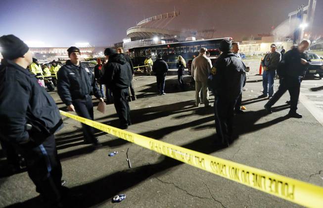 Kansas City, Mo., police work a crime scene in parking lot A outside Arrowhead Stadium, in Kansas City, Mo., after a person was killed Sunday, Dec. 1, 2013. Police Chief Darryl Forte said the death is being investigated as a homicide and that two suspects are in custody.