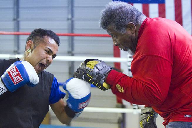 Boxer Yosigey Ramirez, 23, a graduate of Clark High School, works on his timing with trainer Leroy Caldwell during a workout at the Pochiro Boxing gym Tuesday, Dec. 3, 2013. Pochiro Boxing Promotions will hold a boxing card featuring local boxers at Sam's Town Friday.