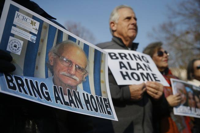 Supporters of Alan Gross, seen on poster at left, hold an event to mark his fourth year in prison in Cuba, Tuesday, Dec. 3, 2013, in Lafayette Park across from the White House in Washington. 