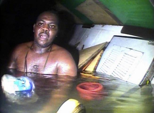 In this image made available Tuesday Dec. 3, 2013, Harrison Odjegba Okene looks in awe as a rescue diver surfaces into the air pocket that kept Okene alive for nearly three days, recorded by the diver's headcam video the full impact of the miraculous encounter becomes plain the see. 


